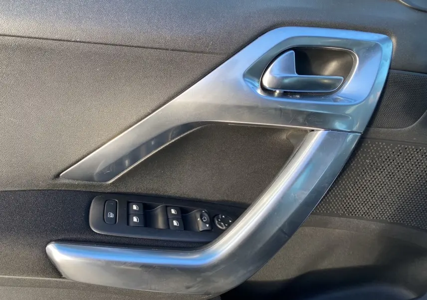 Détail de la poignée intérieure côté gauche gris métallisé avec commandes de vitres du Peugeot 2008 2019.