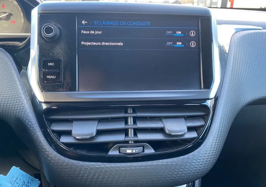 Vue rapprochée de l’écran tactile central du Peugeot 2008 gris platinium de 2019, affichant les réglages d’éclairage de conduite.