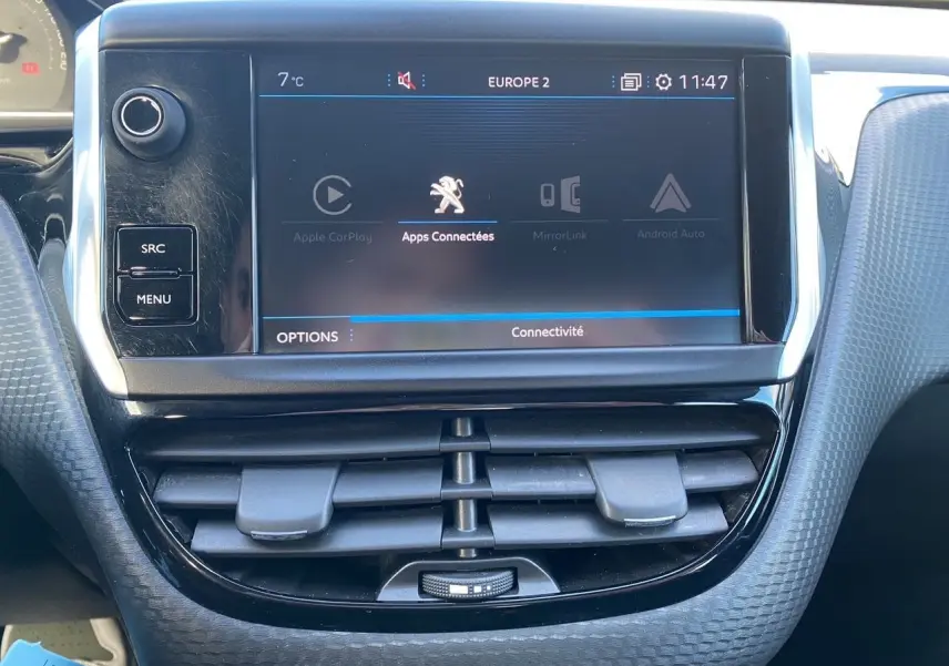 Vue rapprochée de l’écran tactile central et des aérateurs du tableau de bord du Peugeot 2008 gris platinium de 2019.