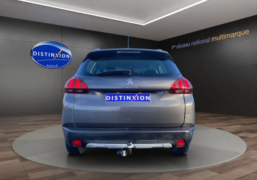 Vue arrière d'un Peugeot 2008 gris platinium 2019 avec attelage visible en showroom.