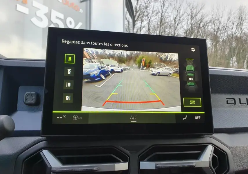 Écran central du tableau de bord du Dacia Duster blanc glacier 2025 montrant la caméra de recul en fonctionnement.