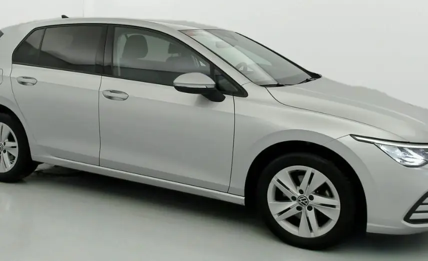 Volkswagen Golf VIII gris reflex vue de profil droit, avec jantes alliage 16 pouces et phares allumés.