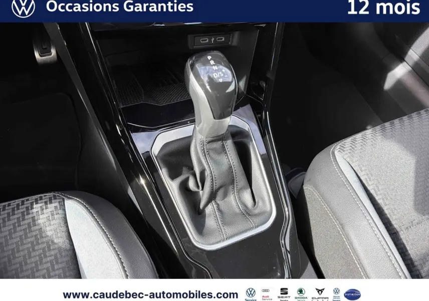 Le levier de vitesse automatique DSG7 au centre de la console d'une Volkswagen T-Roc Cabriolet noire, intérieur clair.