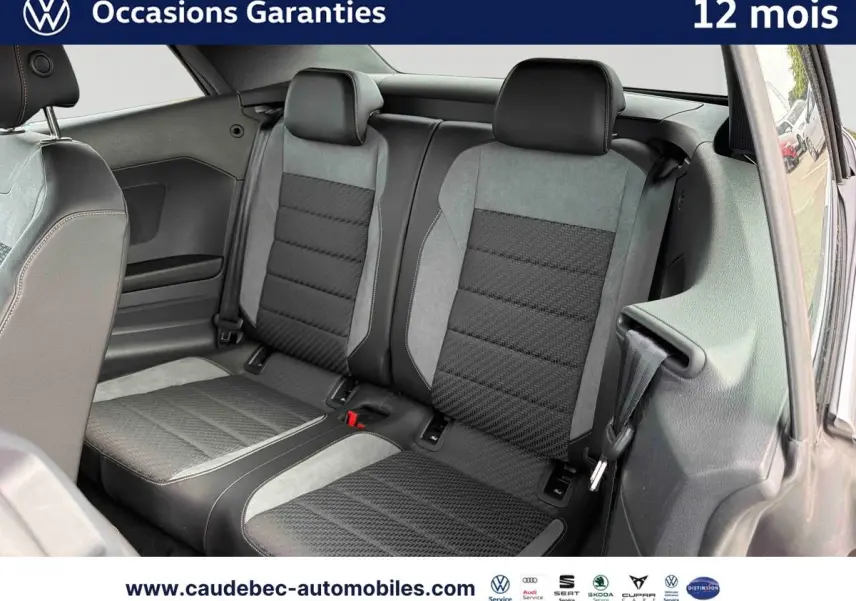 Vue intérieure arrière du Volkswagen T-Roc Cabriolet 2025 montrant les sièges arrière en tissu noir et gris.