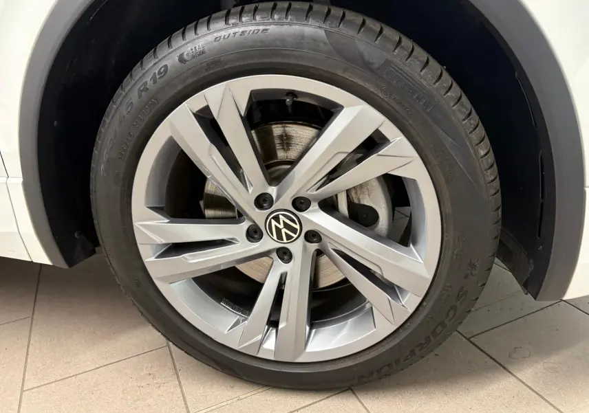 Gros plan sur la roue avant droite du Volkswagen Tiguan blanc pur 2023 avec jante alliage R-Line distinctive.