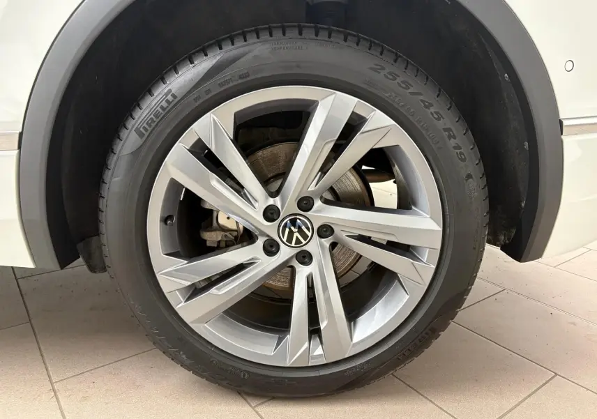 Gros plan sur la roue avant droite du Volkswagen Tiguan blanc pur 2023 avec jante alliage R-Line distinctive.