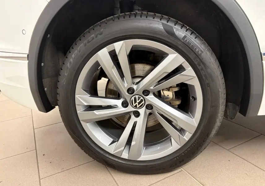 Gros plan sur la roue avant gauche du Volkswagen Tiguan blanc pur 2023 avec jante alliage R-Line distinctive.
