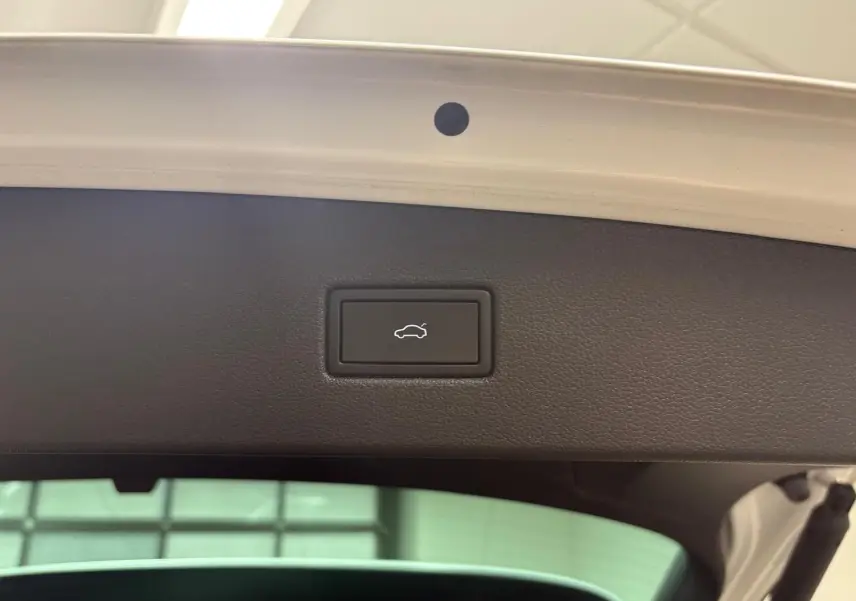 Bouton d'ouverture électrique du coffre sur la partie intérieure du hayon d'un Volkswagen Tiguan blanc pur 2023.