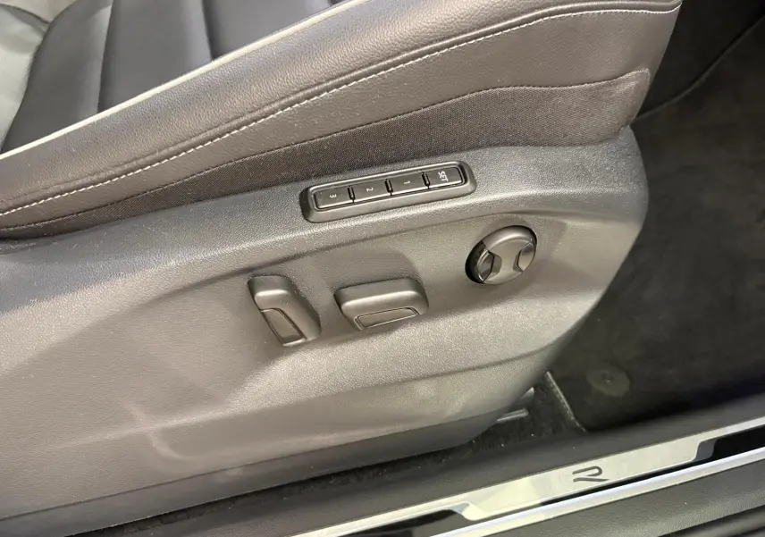 Gros plan sur les commandes de réglage électrique du siège conducteur en cuir noir du Volkswagen Tiguan 2023 R-Line Exclusive.