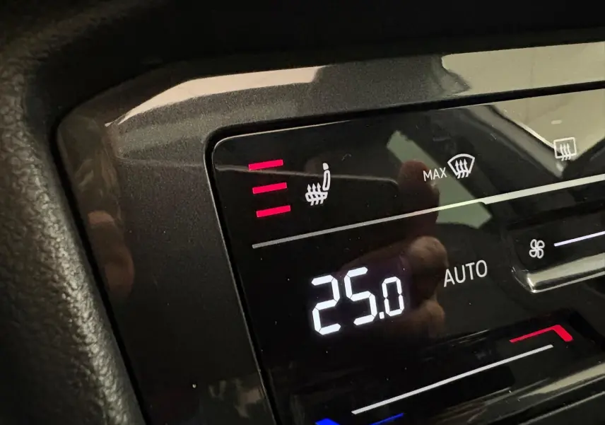 Panneau de commande de la climatisation avec réglage à 25°C et siège chauffant activé dans un Volkswagen Tiguan blanc hybride 2023.