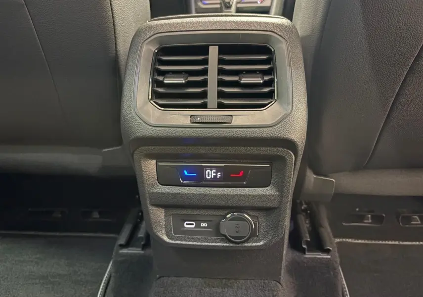 Détail de la console arrière du Volkswagen Tiguan 2023 blanc pur, avec ventilation, commandes de siège chauffant et prises USB et 12V.