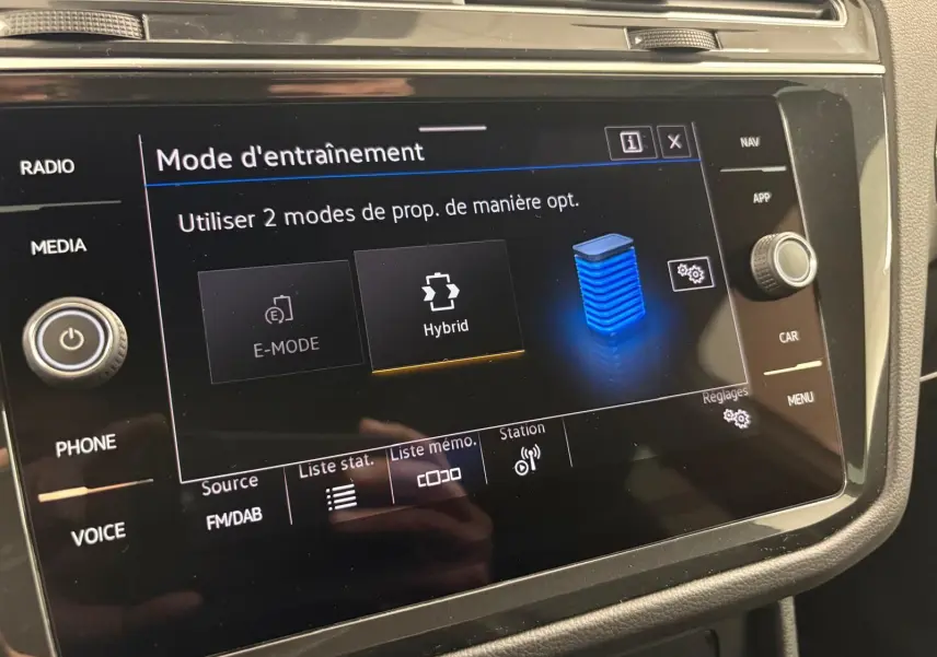 Écran tactile central du Volkswagen Tiguan 1.4 eHybrid 2023 affichant le mode d'entraînement hybride en intérieur noir.