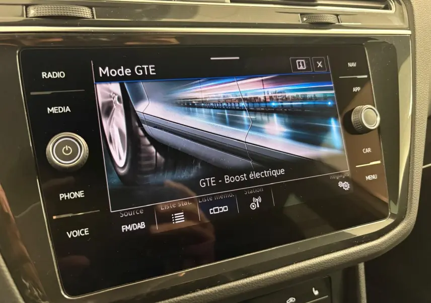 Écran tactile intérieur du Volkswagen Tiguan 2023 blanc pur affichant le mode GTE avec boost électrique en vue rapprochée.