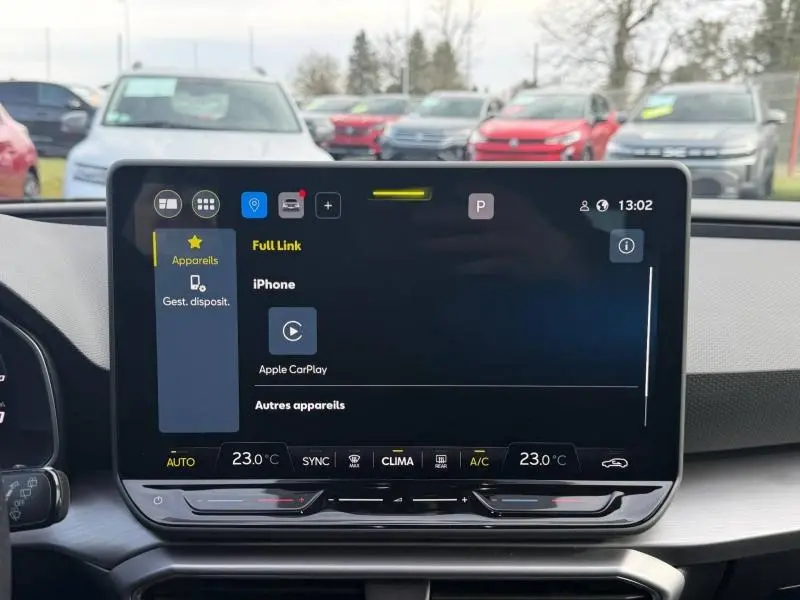 Vue rapprochée de l’écran tactile central du tableau de bord du SEAT LEON ST 1.5 eTSI Hybrid noir Minuit Métallisée, affichant Apple CarPlay.