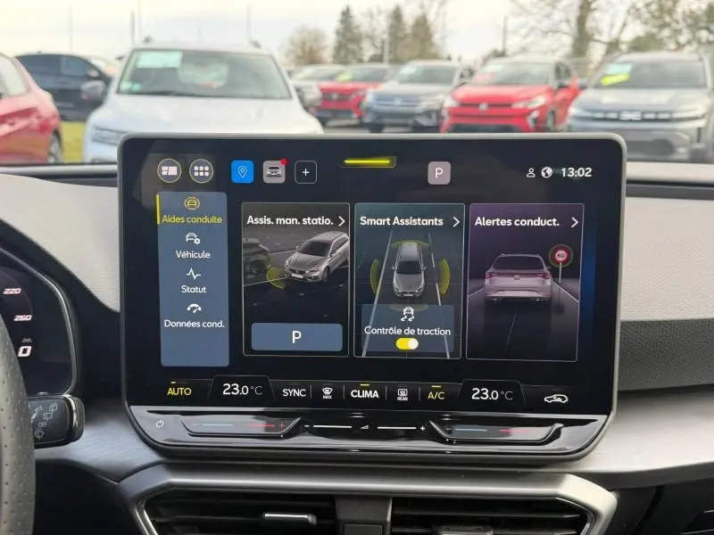 Vue intérieure centrée sur l'écran tactile du tableau de bord du SEAT LEON ST 2025, affichant les aides à la conduite.