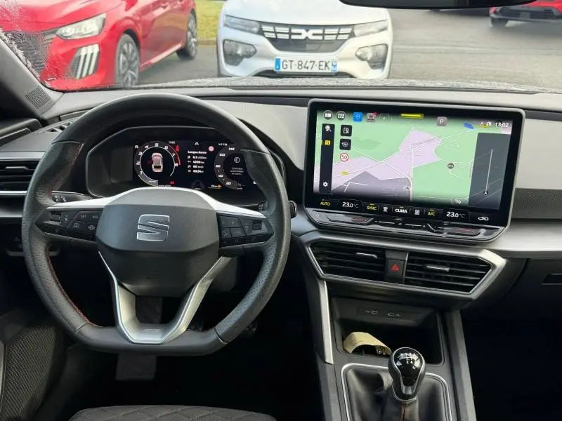 Vue intérieure centrée sur le volant et l'écran tactile du tableau de bord d'une SEAT LEON ST 2025.