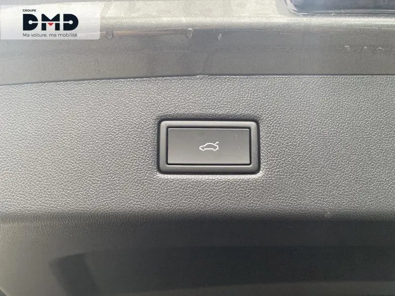 Gros plan sur le bouton d'ouverture électrique du coffre, intérieur noir texturé du Ford Explorer gris Magnetic.