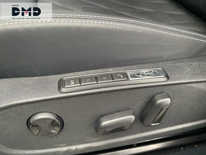 Détail des commandes de réglage électrique du siège conducteur avec logo Ford, finition en cuir noir.