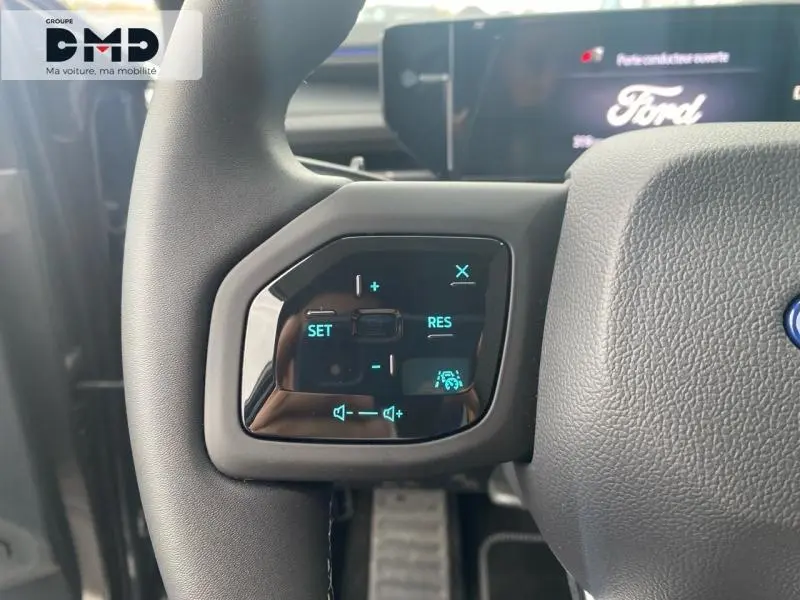 Gros plan sur les commandes au volant du Ford Explorer 2025 gris Magnetic, avec affichage digital bleu.