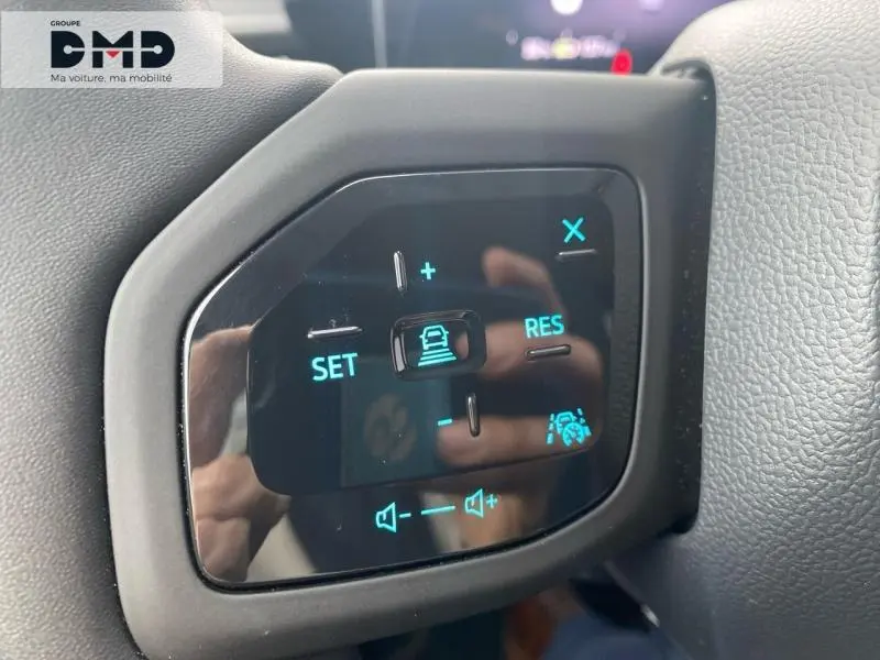 Gros plan sur les commandes au volant du Ford Explorer 2025, affichage bleu sur fond noir, entouré de cuir gris.