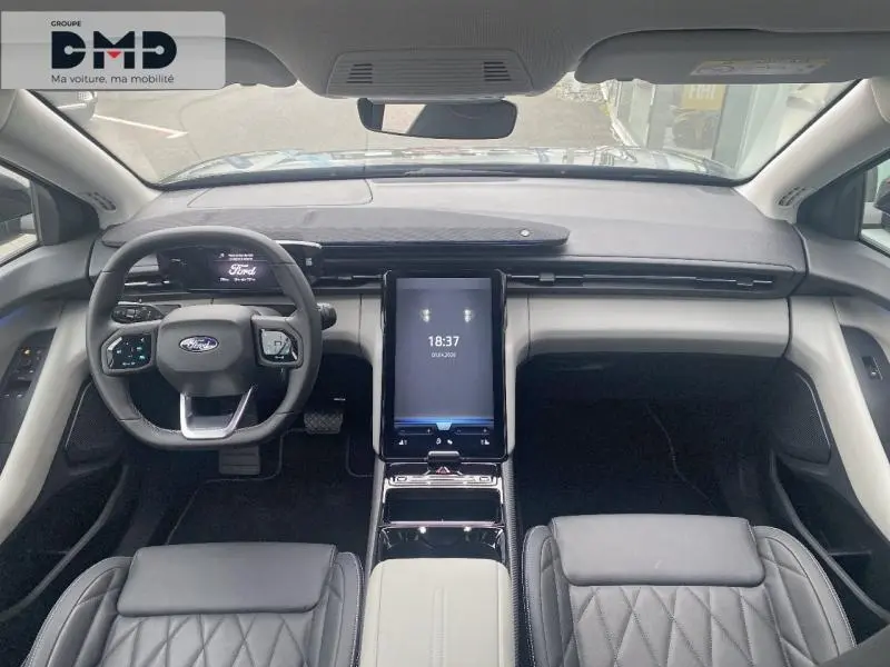Vue intérieure avant du Ford Explorer 2025 avec tableau de bord moderne et sièges cuir noir matelassé.