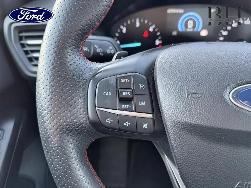 Gros plan sur le volant cuir perforé avec surpiqûres rouges de la Ford Focus 1.5 EcoBlue 2019, boutons multifonctions visibles.