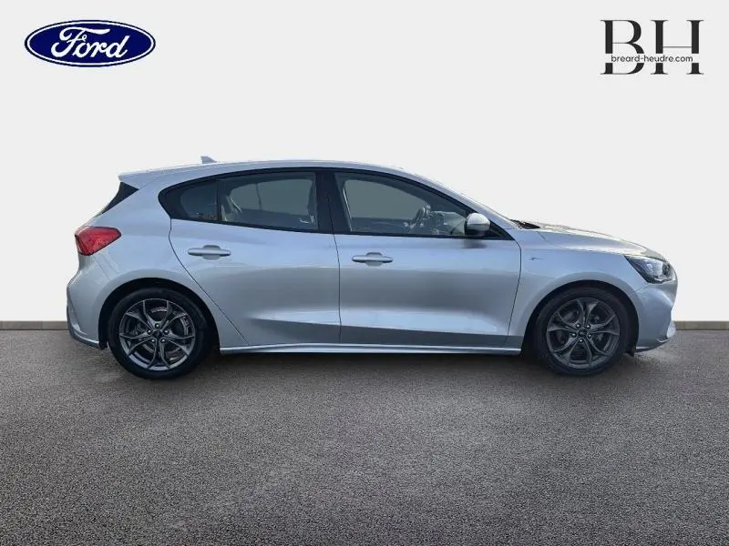 Vue de profil côté gauche d'une Ford Focus gris lunaire métallisé, avec jantes alliage et lignes dynamiques.