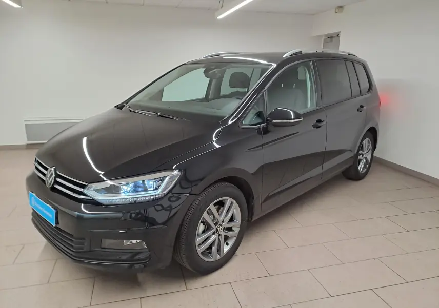 Volkswagen Touran 2025 noir nacré en 3/4 avant droit, avec feux LED et jantes alliage visibles.
