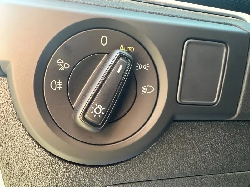 Commande des phares en gros plan dans l'habitacle du Volkswagen T-Cross 2025, avec réglage sur mode automatique.