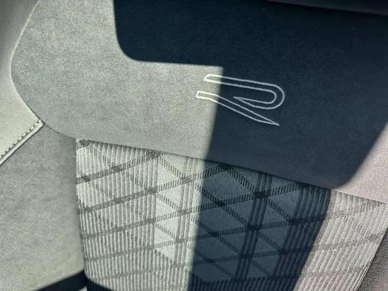 Détail du siège avant avec surpiqûres et logo R brodé sur l’appuie-tête du Volkswagen T-Cross 2025 finition R-Line.