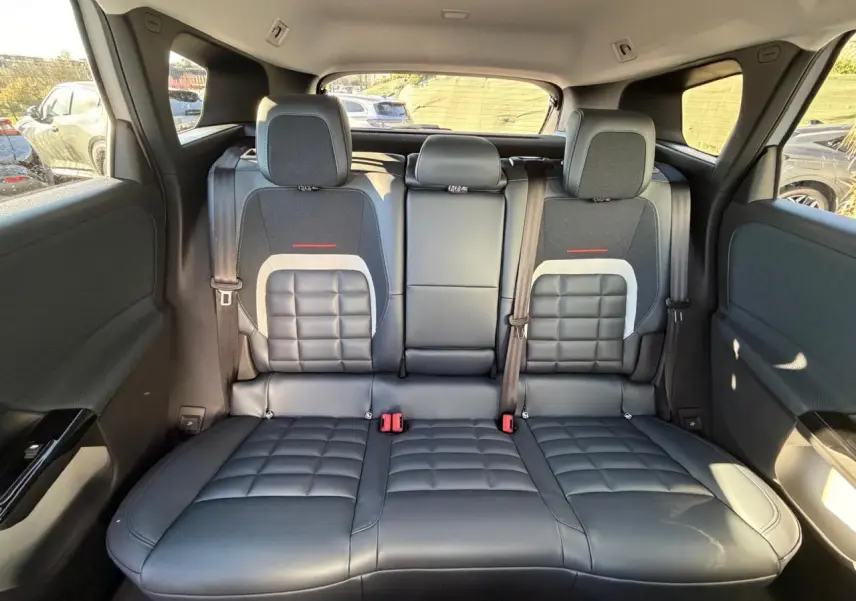 Vue arrière intérieure du Citroën C5 Aircross 2026 montrant la banquette arrière en cuir noir avec inserts tissu et ceintures de sécurité.