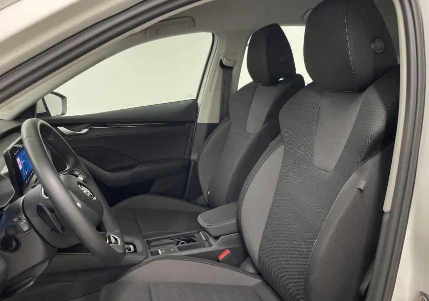 Intérieur de la Skoda Octavia 2024 blanc candy, vue côté gauche montrant sièges avant et tableau de bord moderne.