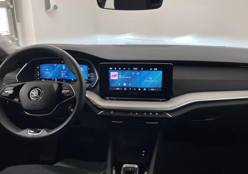 Vue intérieure frontale du tableau de bord et volant noir du Skoda Octavia 2024 avec écran tactile et affichage numérique.