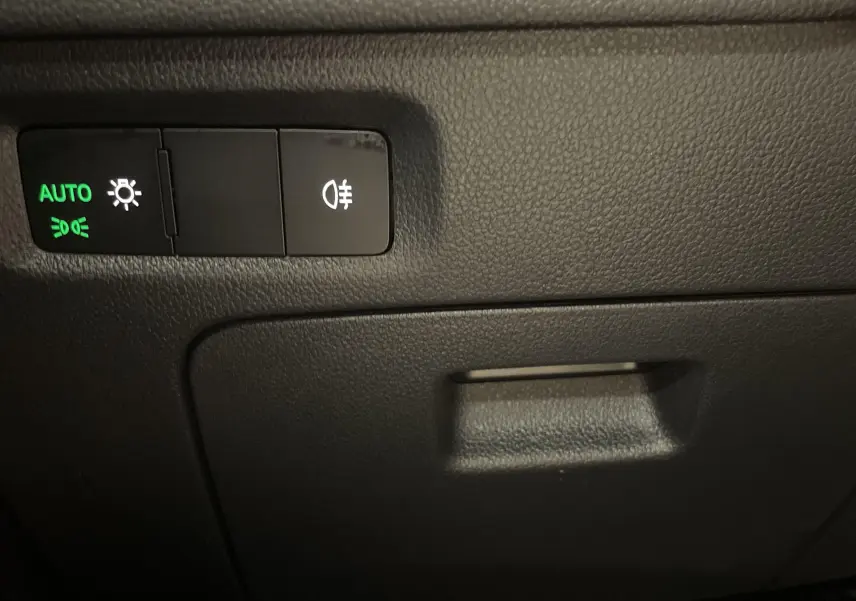 Panneau de commande des feux avec réglage automatique sur Skoda Octavia 2024, intérieur noir.