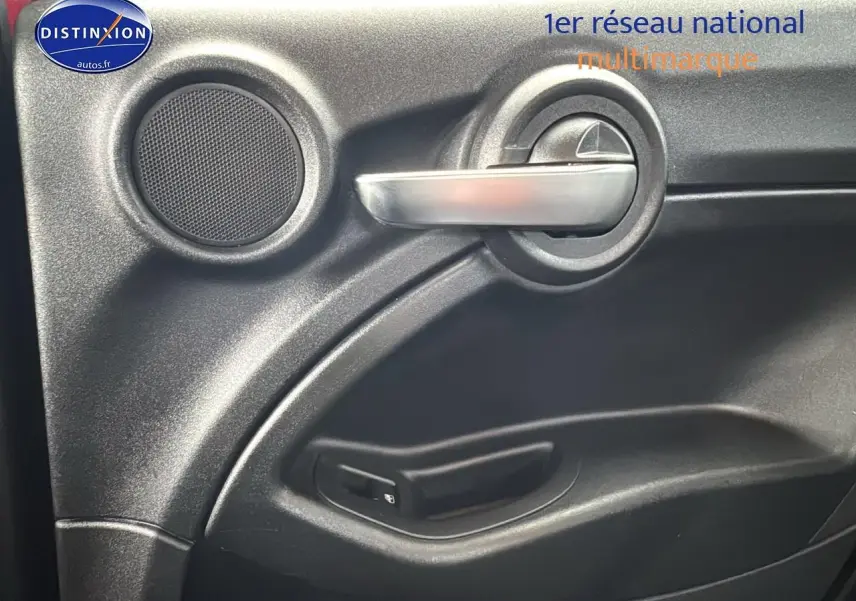 Poignée intérieure argentée et haut-parleur sur la porte côté conducteur d'une FIAT 500X rouge 2020.