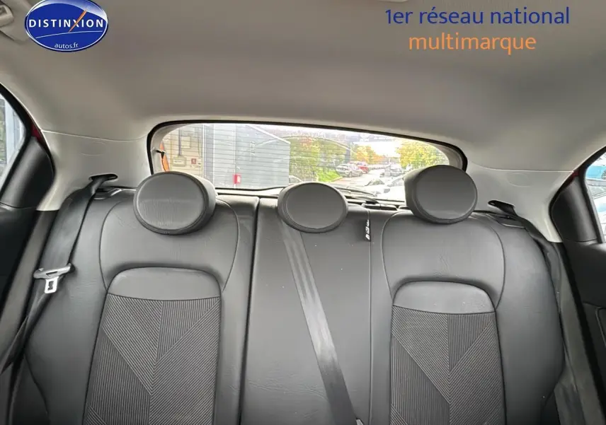 Banquette arrière en cuir noir avec appuie-têtes ronds dans une Fiat 500X rouge, vue de l'intérieur arrière.