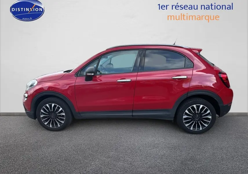 Profil côté gauche d'un FIAT 500X rouge 2020 avec jantes alliage et poignées chromées sur fond neutre.