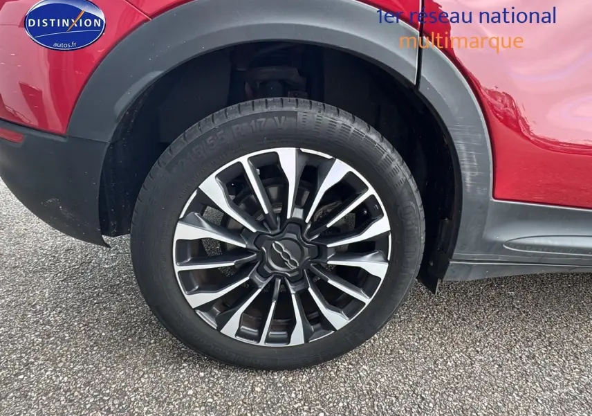 Gros plan sur la roue arrière droite avec jante alu bicolore du FIAT 500X rouge 1.0 firefly 120 lounge de 2020.