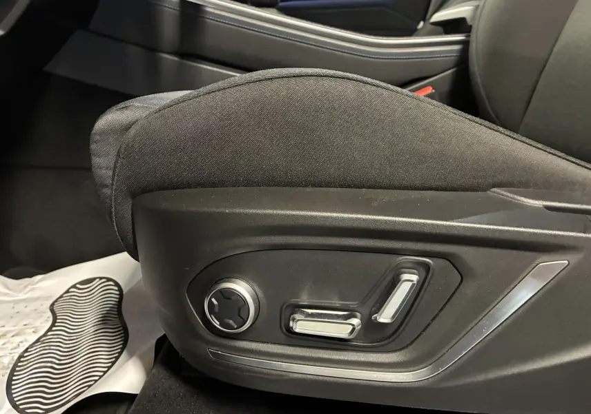 Gros plan sur les commandes électriques du siège avant gauche du LYNK & CO 01 hybride rechargeable bleu 2023.