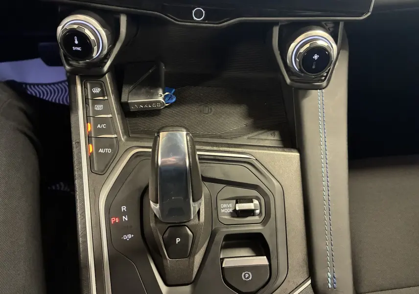 Vue rapprochée de la console centrale du Lynk & Co 01 bleu, avec levier de vitesses automatique et commandes climatisation.