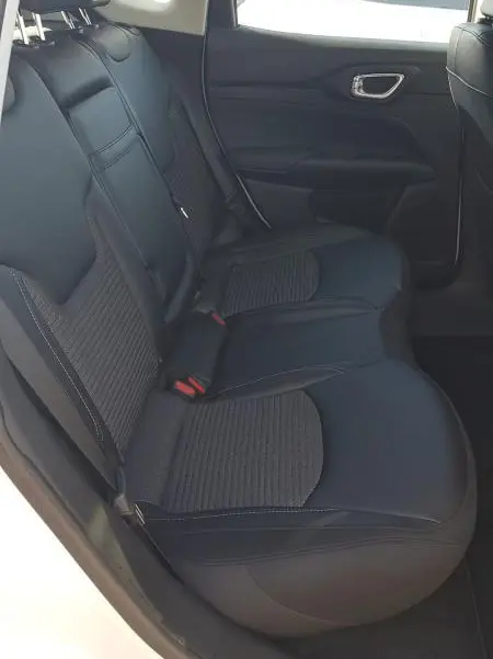 Vue intérieure côté gauche des sièges arrière noirs en cuir et tissu du Jeep Compass blanc 2024 e-Hybrid Altitude.