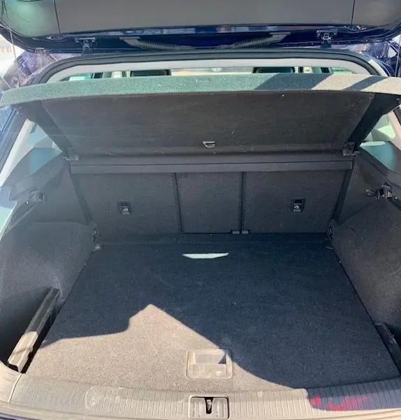 Coffre ouvert du Volkswagen Tiguan 2018 bleu, vue de l'arrière montrant un espace de chargement spacieux et propre.