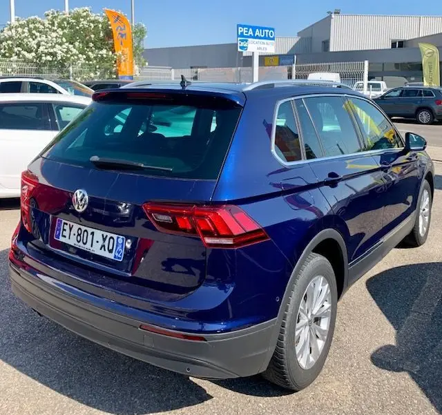 Volkswagen Tiguan bleu 3/4 arrière droit, version 2.0 TDI 150ch confortline business de 2018 en extérieur.