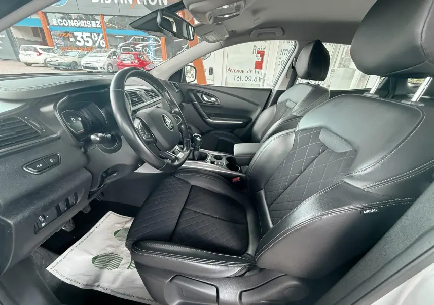 Vue intérieure côté conducteur du Renault Kadjar 1,3 TCE 140CH Intens avec sièges cuir noir et tableau de bord moderne.