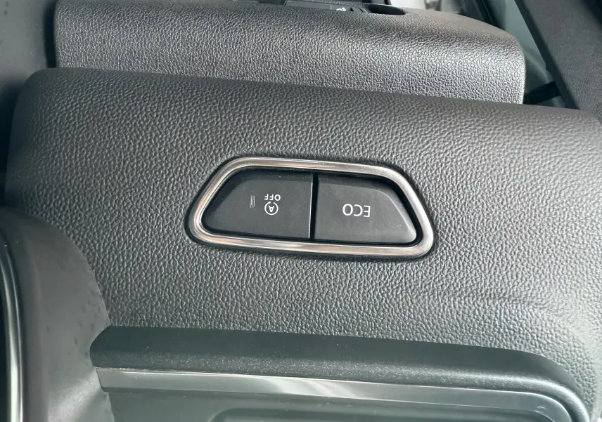 Gros plan sur les boutons ECO et arrêt auto du moteur dans l'habitacle du Renault Kadjar gris 2020.