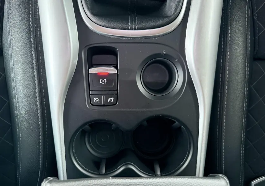 Vue rapprochée de la console centrale du Renault Kadjar gris, montrant le frein à main électronique et porte-gobelets noirs.
