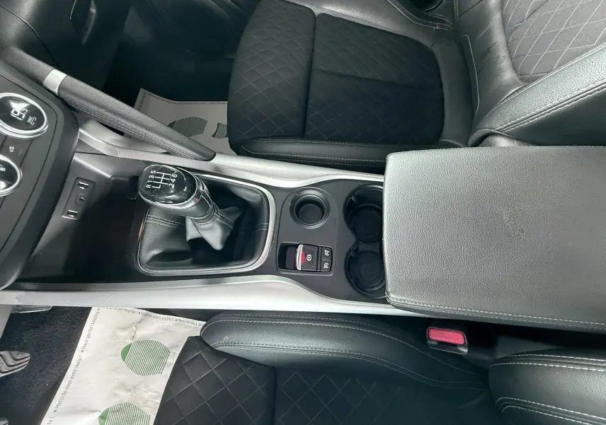 Vue plongeante sur la console centrale du Renault Kadjar gris, montrant la boîte manuelle et les sièges en cuir noir matelassé.