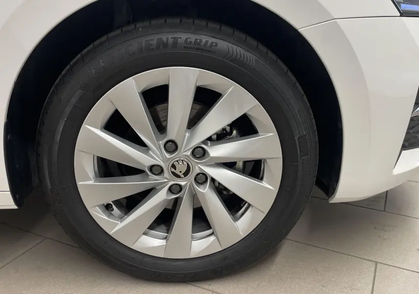 Gros plan sur la roue avant gauche blanche d'une Skoda Octavia 2024 avec jante argentée et pneu Efficient Grip.