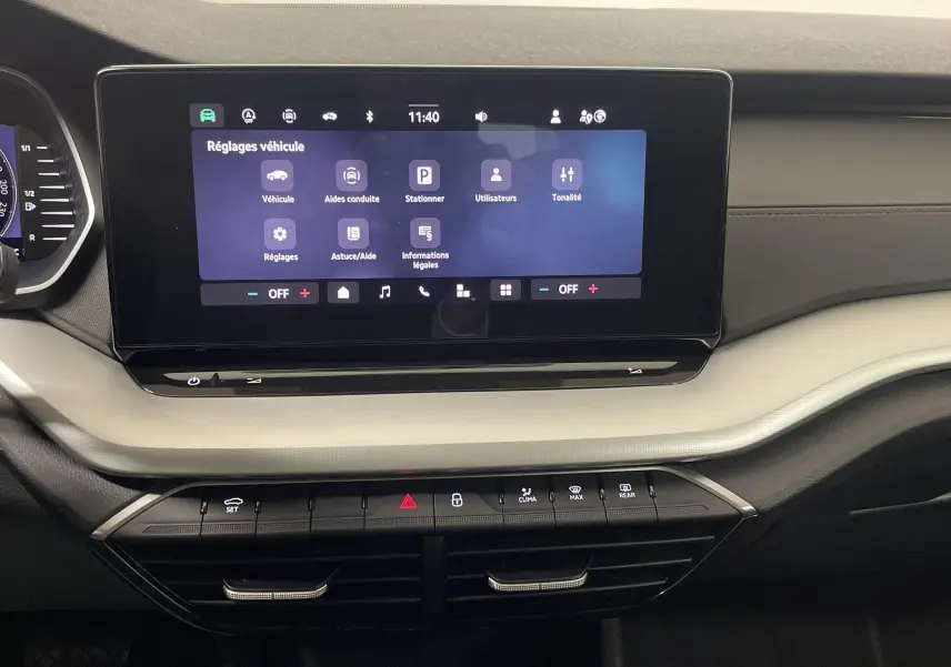 Tableau de bord de la Skoda Octavia 2024 avec écran tactile central et commandes climatisation visibles.