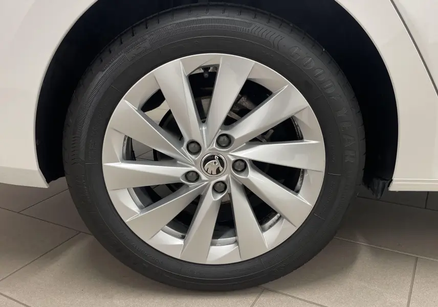 Gros plan sur la roue avant droite blanche d'une Skoda Octavia 2024 avec jante argentée et pneu Goodyear.